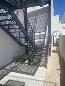 a stairway leading up to a building with a metal structure at CASA ANALUCIA in Faro +2 photos