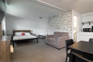 a bedroom with a bed and a couch and a chair at Lumber Jill Lodge in Balsam Lake