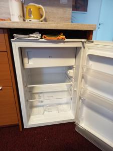 an empty refrigerator with its door open in a kitchen at Ubytování u Macochy in Vilémovice