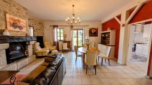 a living room with a couch and a fireplace at Les tuilières in Masléon