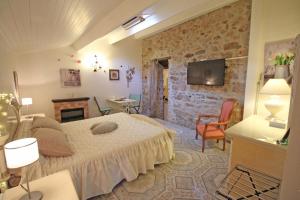 a bedroom with a bed and a stone wall at Les tuilières in Masléon