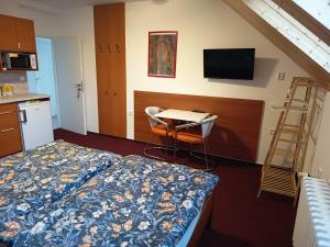 a hotel room with a bed and a table and a desk at Ubytování u Macochy in Vilémovice
