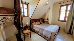 a small bedroom with a bed and a chair at Les tuilières in Masléon