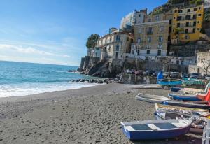 a beach with boats on the sand and buildings at Milion's House Apartments in Minori