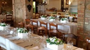 a dining room with tables and chairs with flowers on them at La Locanda in Aviano
