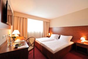 a hotel room with a bed and a desk at CityHotel Dormagen in Dormagen +5 photos