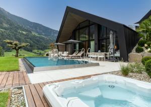 a house with a jacuzzi in the yard at Andreus Resorts in San Leonardo in Passiria +44 photos