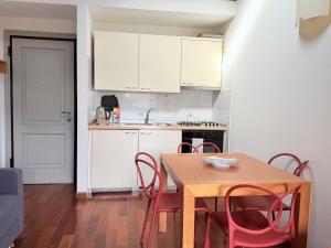 a kitchen with a wooden table and red chairs at Casa Petrucci centro storico, accesso ztl e park gratuito in Forlì