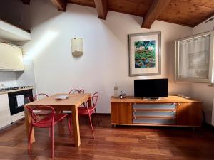 a kitchen with a table and chairs and a television at Casa Petrucci centro storico, accesso ztl e park gratuito in Forlì