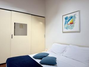 a bedroom with a bed with blue pillows on it at Casa Petrucci centro storico, accesso ztl e park gratuito in Forlì +14 photos