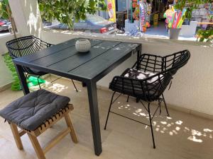 a black table with two chairs and a vase on it at Astradeni Suite in Nea Potidaea