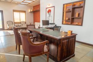 an office with a wooden desk with chairs and a table at Vanthra Vilas, Jawai - Luxury Villas with Private Pools in Bijāpur