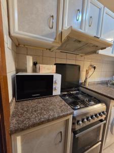 a kitchen with a stove and a microwave at Apartment in ajman in Ajman 
