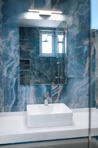 a bathroom with a white sink and a mirror at ILIADA Boutique Rooms in Faliraki +70 photos