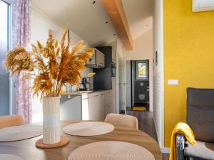 a dining room with a table with a vase with a plant at Eco Holiday Home - Airco & Panoramisch uitzicht - Achterhoek in Almen
