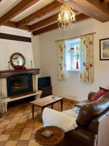 a living room with a couch and a fireplace at Reves au Soleil in Thiviers