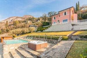 a home with a swimming pool and a house at Villa La Perledina in Perledo