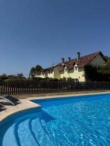 a swimming pool in front of a house at Reves au Soleil in Thiviers