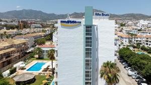 a tall white building with a pool in front of a city at MedPlaya Hotel Alba Beach in Benalmádena