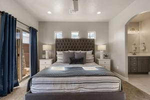 a bedroom with a large bed with blue curtains at Zion Adventure townhouse in Hurricane