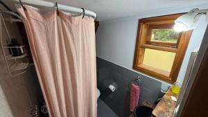 a bathroom with a shower curtain and a window at Complejo Aiken in Villa Traful +50 photos