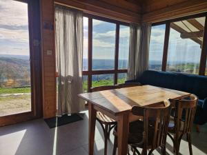 a wooden table and chairs in a room with windows at Chalet "Quelle Vue" in Coubisou +36 photos