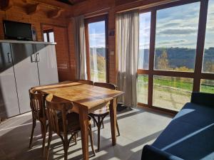 a wooden table and chairs in a room with a large window at Chalet "Quelle Vue" in Coubisou