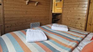 a bed in a room with two towels on it at Chalet "Quelle Vue" in Coubisou