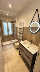 a bathroom with a sink and a toilet and a mirror at Boutique Apartments Magenta in Magenta +11 photos