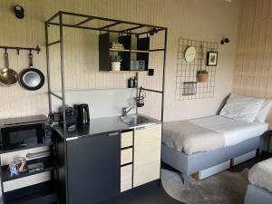 a room with a bed and a sink in a room at Studio op Camperplaats Vechtdal in Nieuwleusen