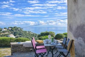 a table and chairs on a patio with a view of the ocean at Villa A Ventosa in Bastia