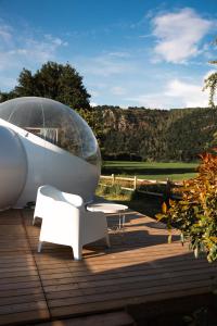 a glass dome sitting on top of a wooden deck at Bulle à la Belle étoile in Clécy
