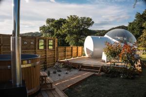 a garden with a wooden deck and a glass dome at Bulle à la Belle étoile in Clécy