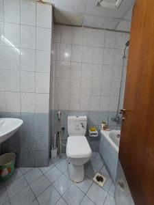 a bathroom with a toilet and a sink and a tub at Apartment in ajman in Ajman  +10 photos