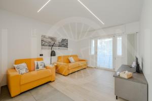 a living room with two orange couches and a table at Le Lion Apartments - Bike & Ski in Aosta