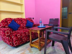 a living room with a couch and a table and chairs at Ocean Wind Homestay in Pondicherry +8 photos