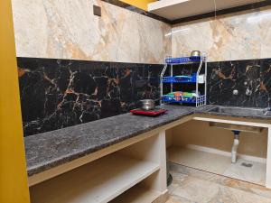 a kitchen with a granite counter top and a sink at Ocean Wind Homestay in Pondicherry