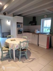 a kitchen with a table and chairs in a room at Bordeneuve in Le Passage