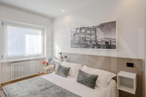 a white bedroom with a bed and a window at Le Lion Apartments - Bike & Ski in Aosta