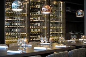 a row of tables in a restaurant with wine racks at NH Bussum Jan Tabak in Bussum