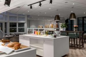 a bakery with a counter with food on it at NH Bussum Jan Tabak in Bussum +42 photos