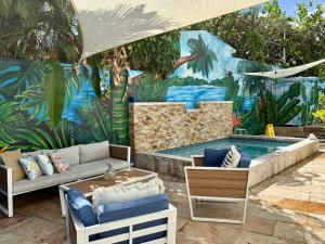 ein Wandgemälde eines Schwimmbads mit Sofa und Stühlen in der Unterkunft Salitre Studio - Shared Pool Access in Mameyal