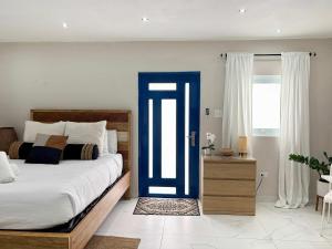 ein Schlafzimmer mit einem Bett und einer blauen Tür in der Unterkunft Salitre Studio - Shared Pool Access in Mameyal