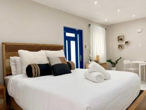 ein Schlafzimmer mit einem großen weißen Bett und Kissen in der Unterkunft Salitre Studio - Shared Pool Access in Mameyal