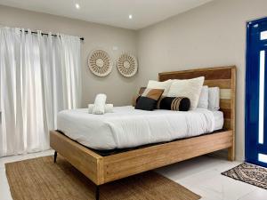 ein Schlafzimmer mit einem großen Bett mit weißen Laken und Kissen in der Unterkunft Salitre Studio - Shared Pool Access in Mameyal + 11 Fotos