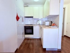 a small kitchen with white cabinets and a sink at Casa Petrucci 2 centro storico, accesso ztl e park gratuito in Forlì
