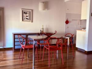 a dining room with a table and red chairs at Casa Petrucci 2 centro storico, accesso ztl e park gratuito in Forlì