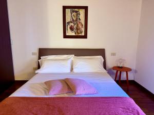 a bedroom with a bed with two pillows on it at Casa Petrucci 2 centro storico, accesso ztl e park gratuito in Forlì