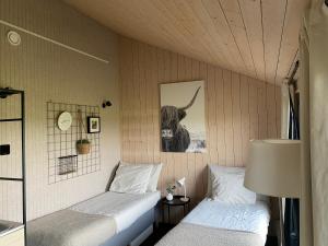 a bedroom with two beds and a picture of a bull at Studio op Camperplaats Vechtdal in Nieuwleusen
