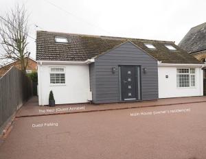 a grey and white house with a black door at The Nest in Needingworth